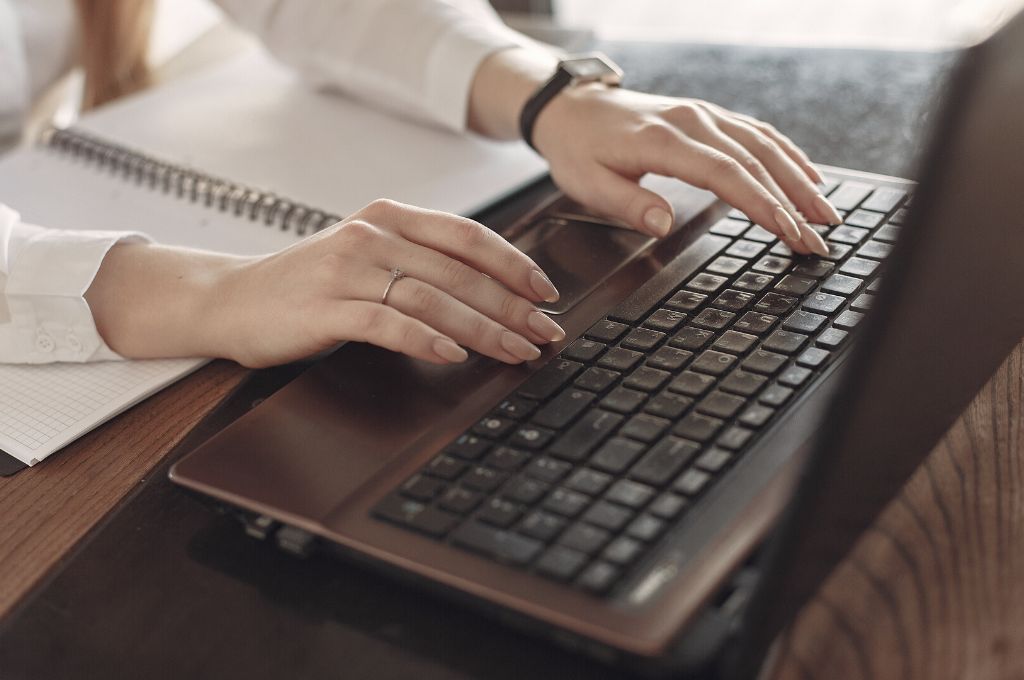 Hands typing on a computer keyboard 